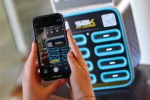 Stazione Caricami personalizzata per l'evento WorldSBK con in primo piano telefono che scansiona il QR code per noleggiare un powerbank.